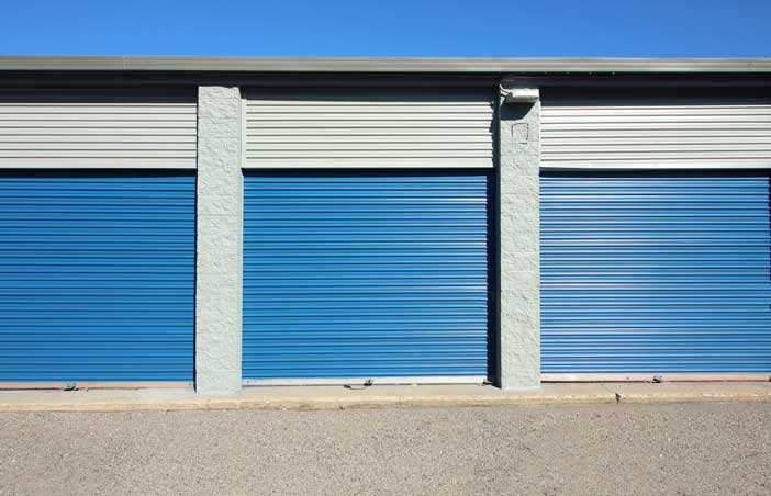 Large drive-up storage units with roll-up doors.